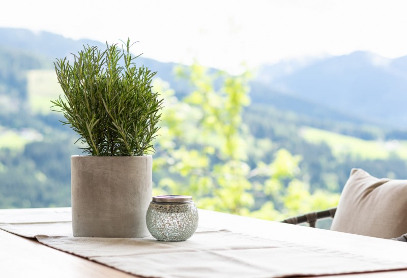 Dekoration mit Rosmarin und Kerze auf dem Terrassentisch