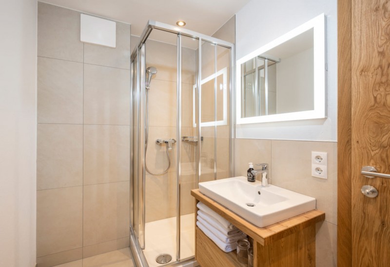 Badezimmer mit Waschbecken, Spiegel und Dusche