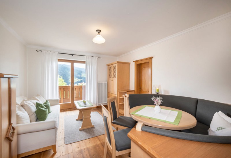 Essbereich und Couch mit Ausgang zum Balkon